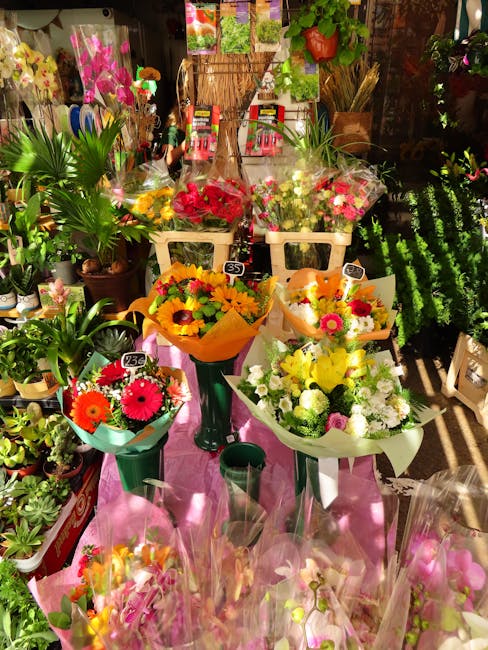 A vibrant display of floral arrangements and bouquets inside Crouch End Florist, showcasing a variety of fresh flowers including bright pink gerbera daisies, yellow sunflowers, white chrysanthemums, a